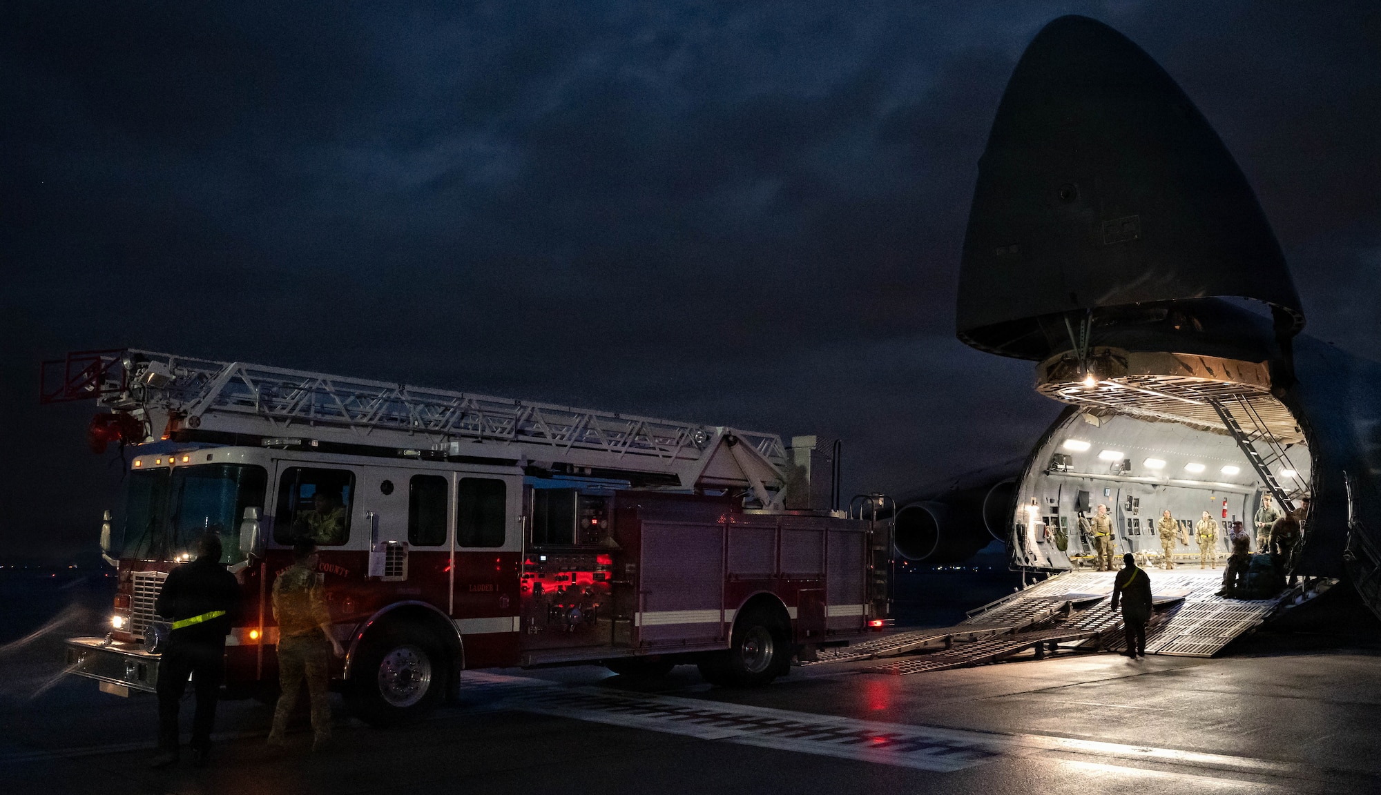 A firetruck backs into a C-5 Galaxy aircraft