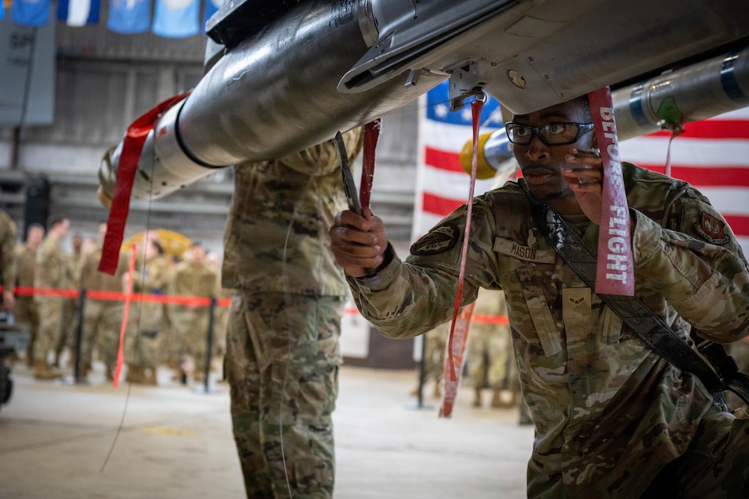 U.S. Air Force Airmen threads a wire through a munition.