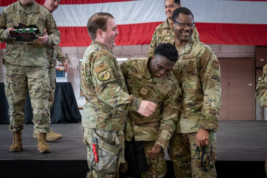 Three U.S. Air Force Airmen smile.