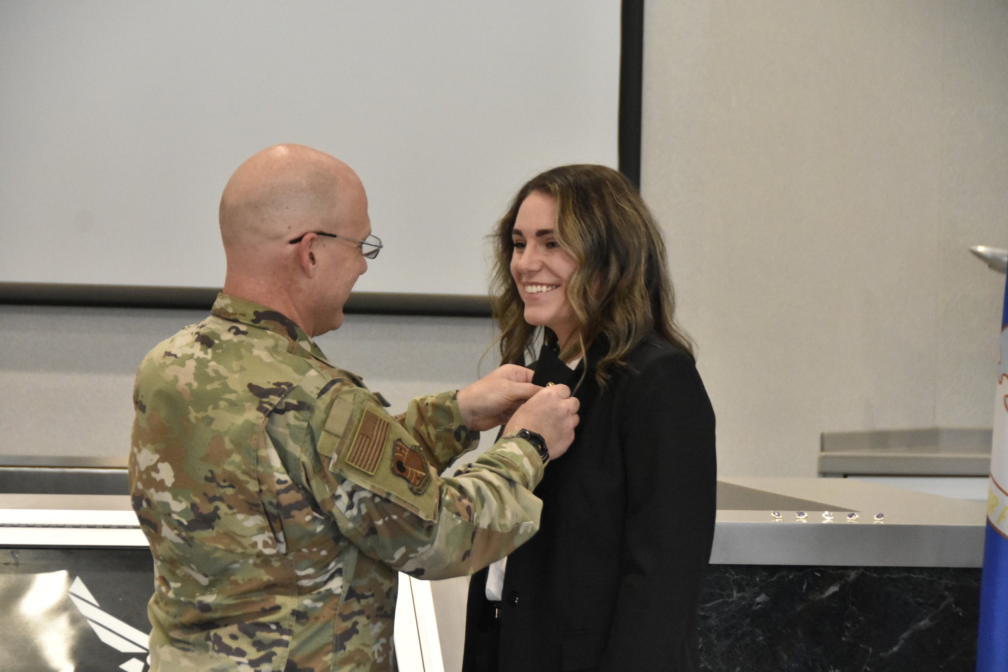 Hope Nunley, executive director of the Tullahoma Area Chamber of Commerce, right, receives her Honorary Commander lapel pin from Test Support Division Commander Col. Eric Withrow during the March 8, 2024, ceremony at Arnold Air Force Base, Tenn., to induct the first class of Arnold AFB Honorary Commanders. Arnold AFB is the headquarters of AEDC. (U.S. Air Force photo by Brad Hicks)