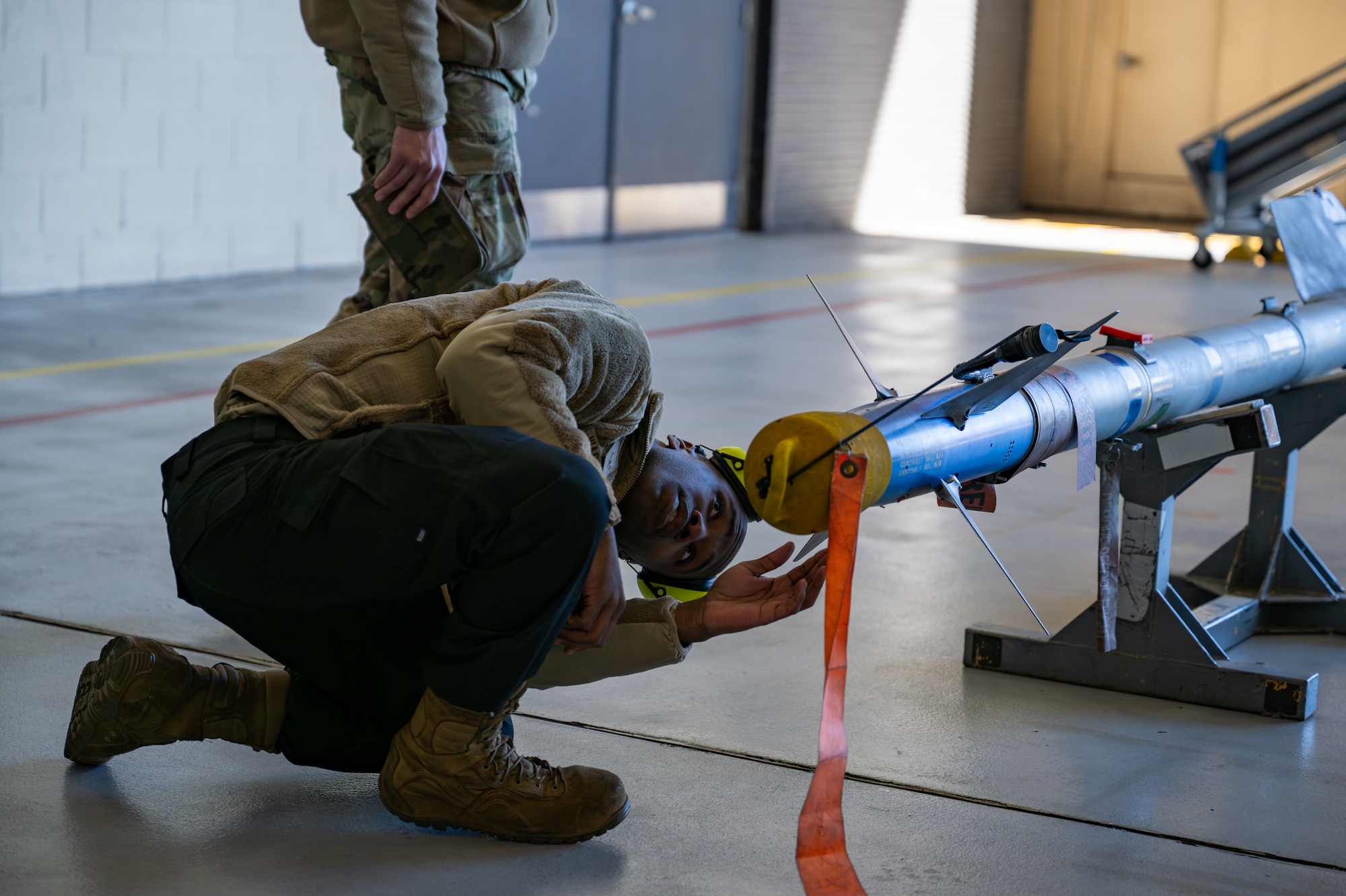 Man bends down to examine bomb.