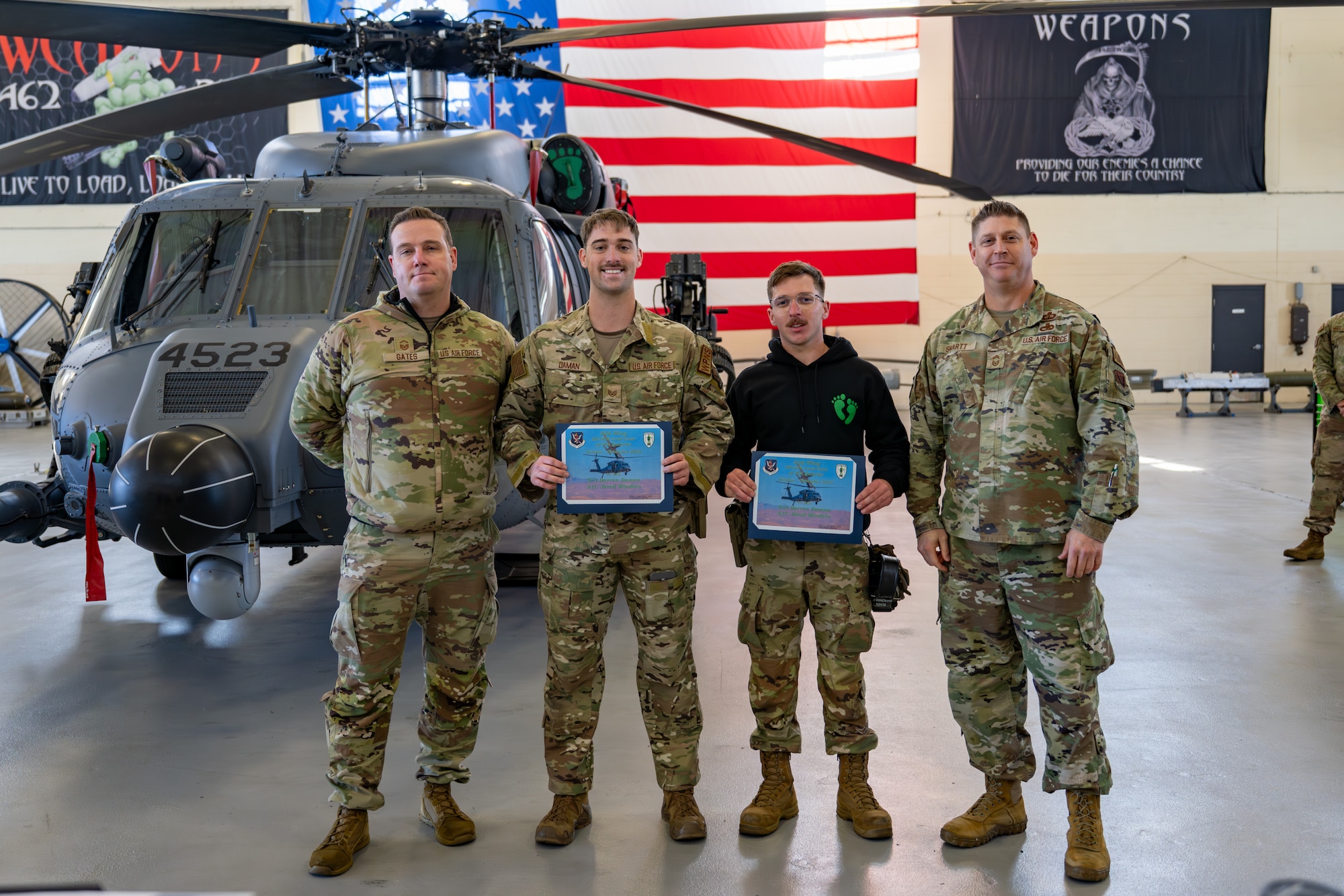 Men pose with certificates.