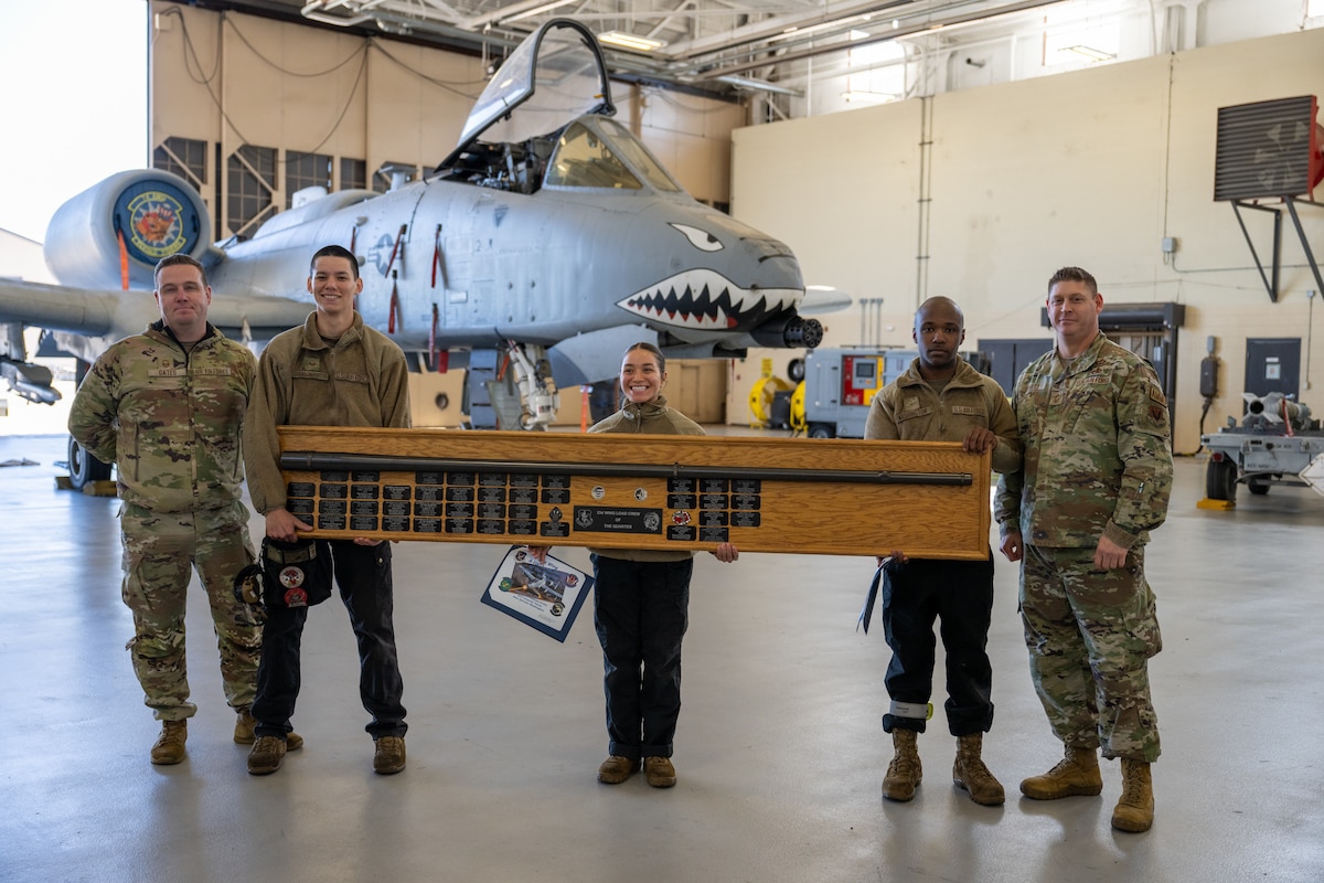 People pose for photo while holding award.