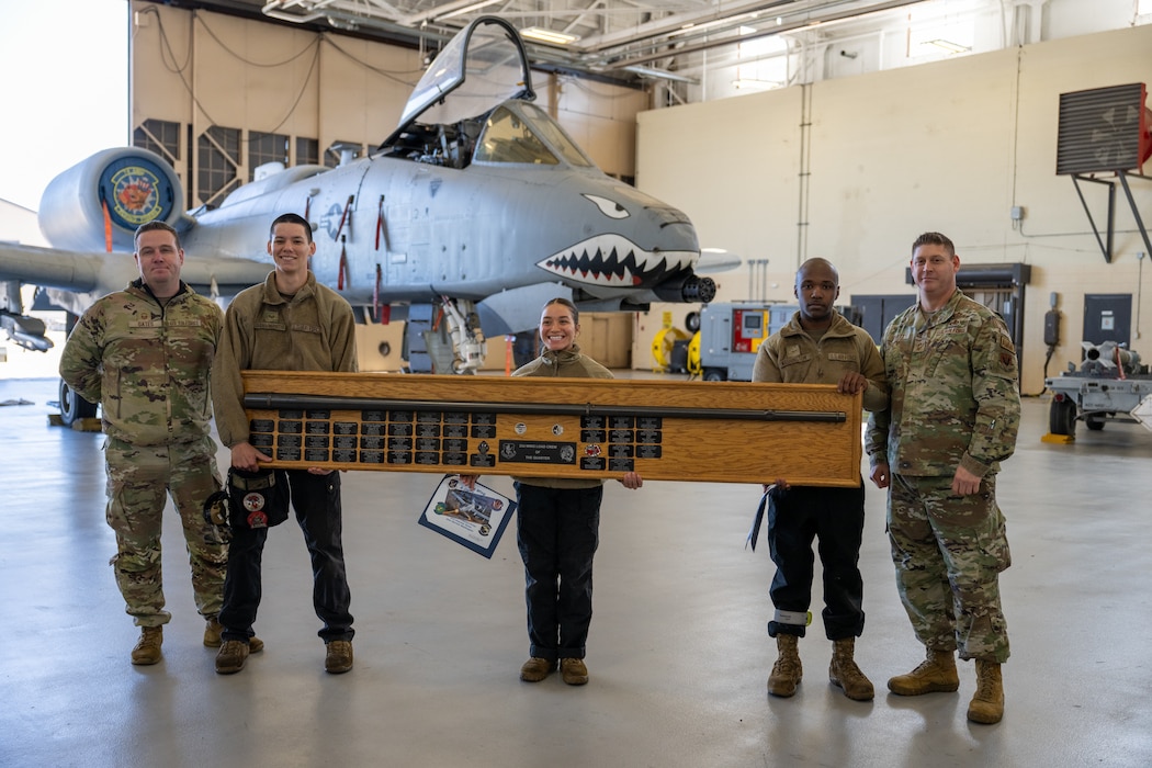 People pose for photo while holding award.