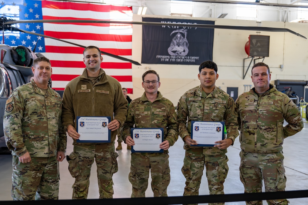Men pose with certificates.