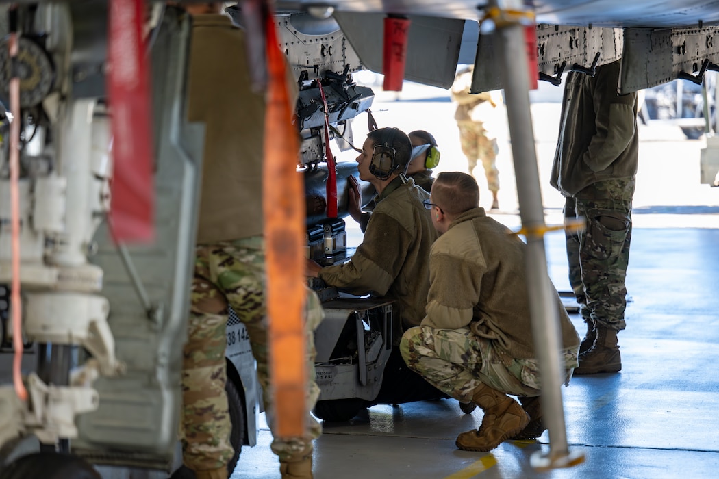 Men direct others while working on machinery.