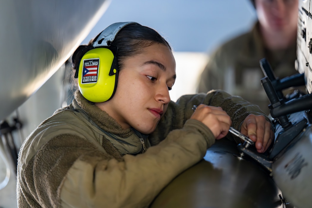 Woman works on machinery.