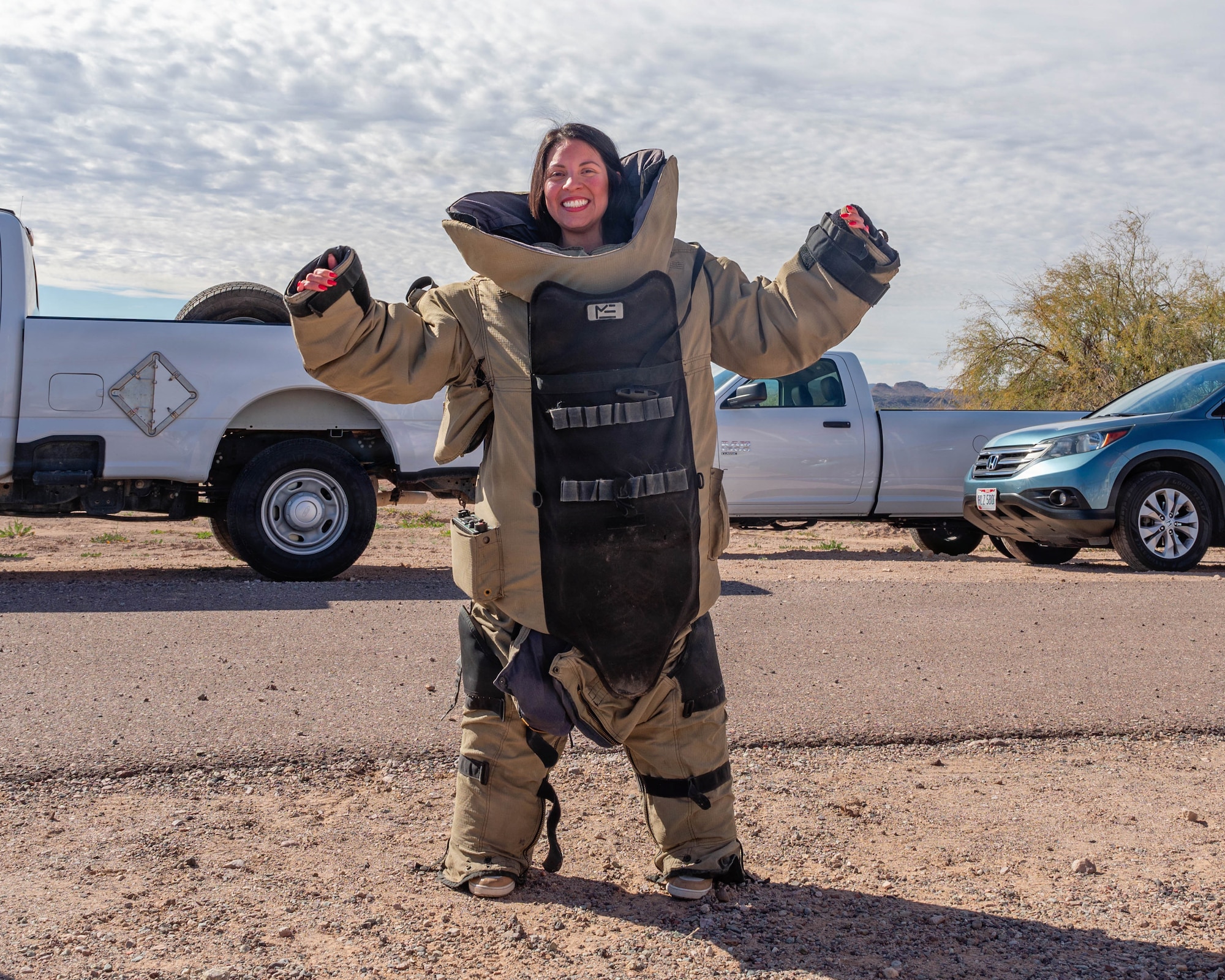 Elizabeth Canchola, 310th Fighter Squadron honorary commander, poses for a photo in an Explosive Ordnance Disposal bomb suit, Jan. 22, 2026, at the Barry M. Goldwater Range, Arizona. The simulated deployment provided community leaders with a firsthand look at Luke Air Force Base’s mission, people, and daily operations. Their involvement strengthened mutual understanding and built lasting partnerships between the base and the surrounding community.  (U.S. Air Force photo by Airman 1st Class Tekorey Watkins)