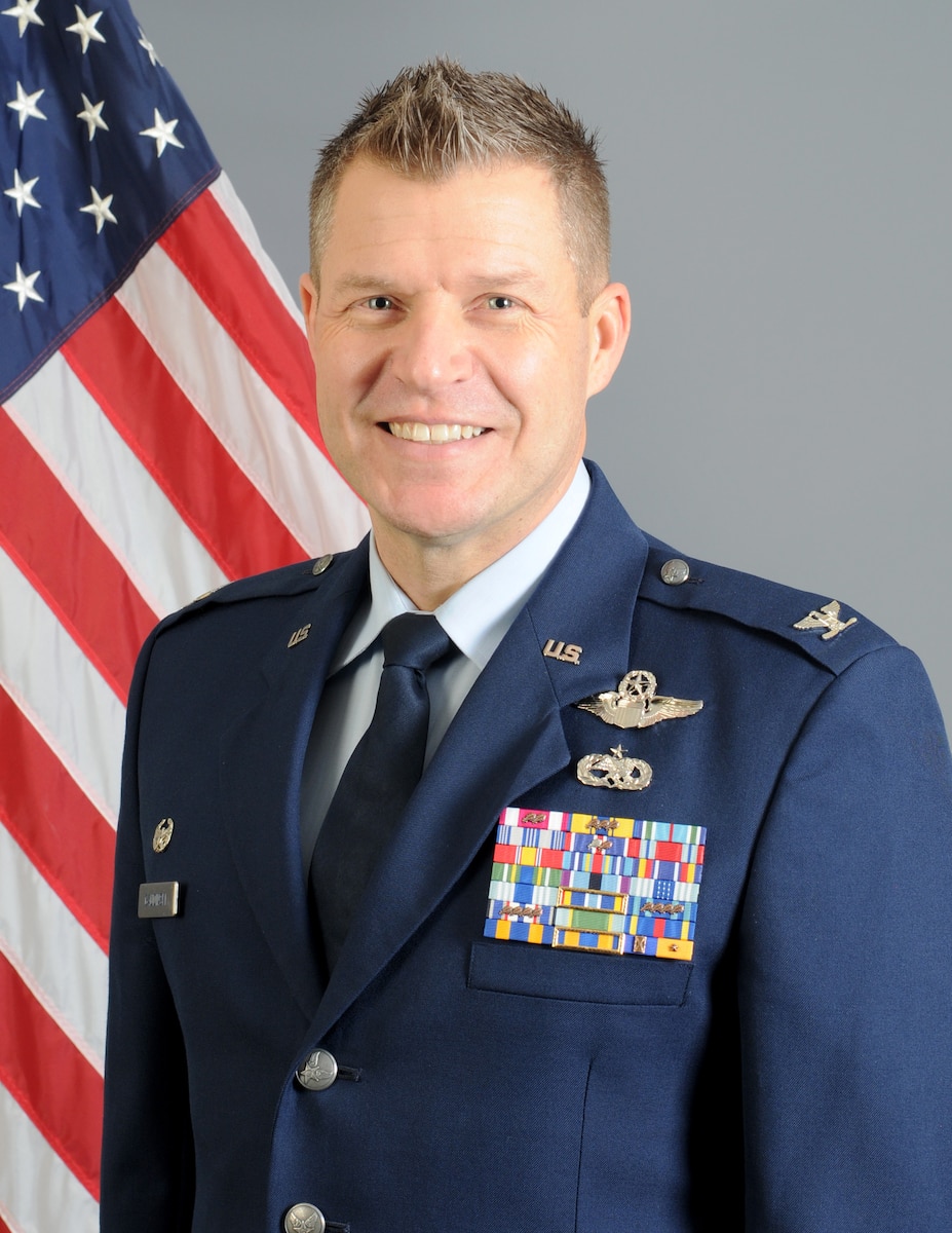 Person poses for picture in front of U.S. flag