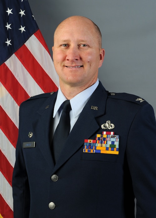 Person poses for photo in front of U.S. flag