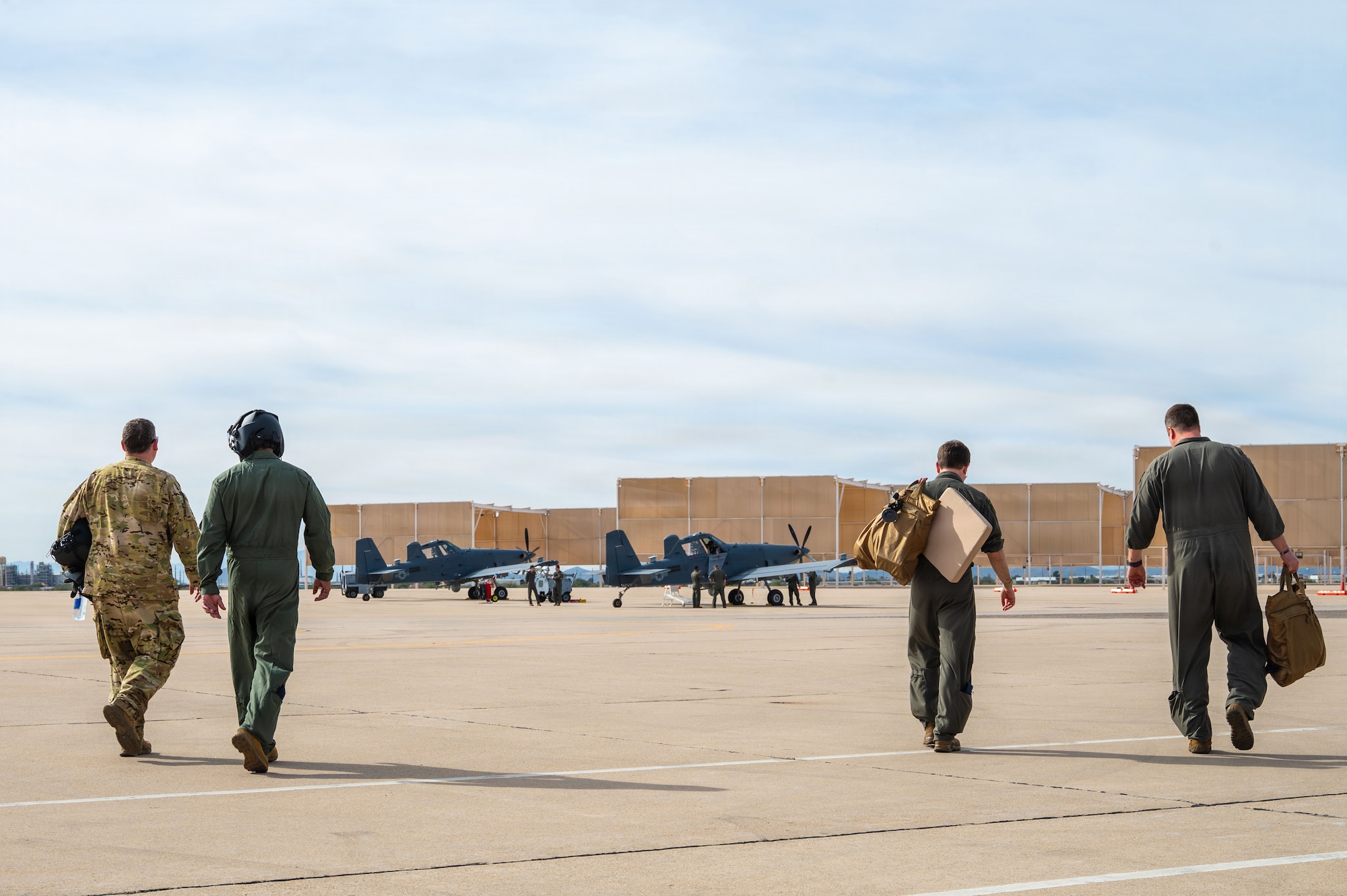U.S. Air Force Col. Charles Redmond, 355th Wing deputy commander, far left; Chief Master Sgt. Kelvin Hatcher, 355th WG command chief, left; and pilots assigned to the 492nd Special Operations Wing approach two OA-1K Skyraider II aircraft at Davis-Monthan Air Force Base, Arizona, Jan. 21, 2026. The Skyraider II will provide special operations forces the ability to tailor effects to support the joint force delivering close air support, precision strike, and intelligence, surveillance and reconnaissance capability. (U.S. Air Force photo by Senior Airman Jasmyne Bridgers-Matos)