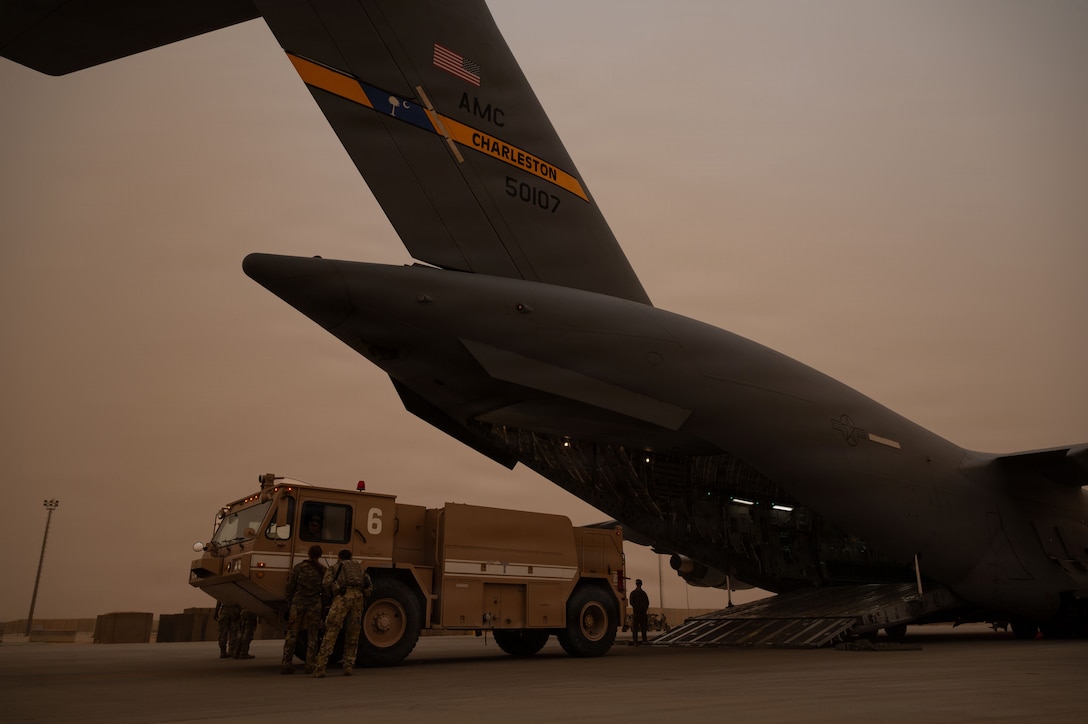 U.S. Airmen load a fire truck as cargo onto a C-17 Globemaster III aircraft during a mission in the U.S. Central Command area of responsibility, Dec. 29, 2025. The C-17 deployed to the CENTCOM AOR to help defend U.S. interests, promote regional security and deter aggression in the region. (U.S. Air Force photo by Tech. Sgt. Bailee A. Darbasie)