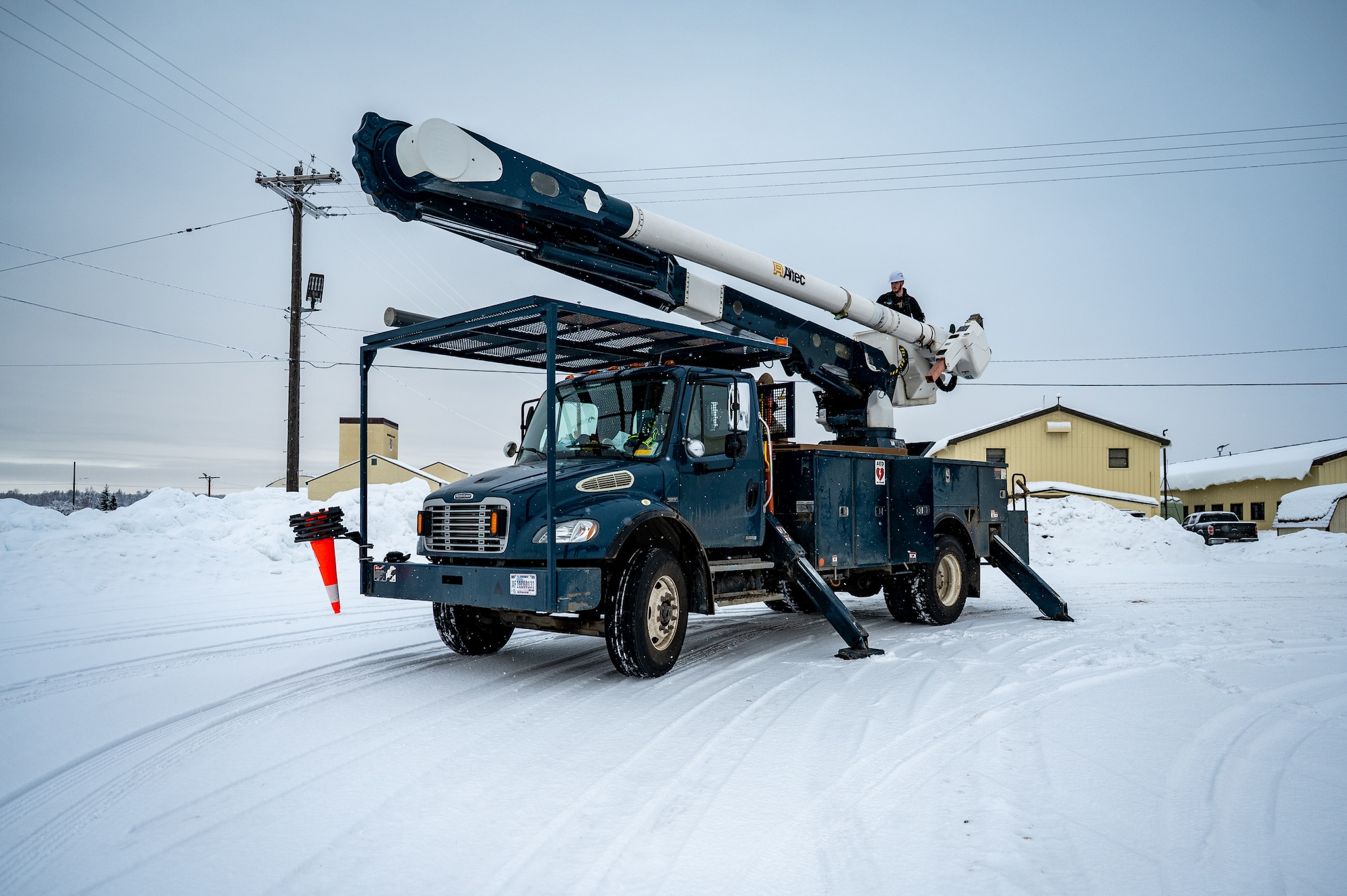 Isaac Larock, 773d Civil Engineer Squadron electrical systems crew leader, operates the aerial lift of a utility truck at Joint Base Elmendorf-Richardson, Alaska, Jan. 26, 2026. The electrical team responds to adverse, weather-related incidents across the installation. (U.S. Air Force photo by Senior Airman Hunter Hites)