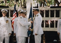 JOINT BASE PEARL HARBOR-HICKAM, Hawaii (Jan. 16, 2026) - Capt. Chris Hedrick, commodore, Submarine Squadron 1, left, presents Cmdr. Johannes Smith, outgoing commanding officer of the Virginia-class fast-attack submarine USS Illinois (SSN 786), right, with his end of tour award during the change of command ceremony for Illinois at the USS Parche Park and Submarine Memorial on Joint Base Pearl Harbor-Hickam, Hawaii, Jan. 16, 2026. Illinois is assigned to Submarine Squadron 1 and is capable of supporting various missions, including anti-submarine warfare, anti-surface ship warfare, strike warfare, special operations forces support, and intelligence, surveillance, and reconnaissance. (U.S. Navy photo by Mass Communication Specialist 2nd Class Nicholas Russell)
