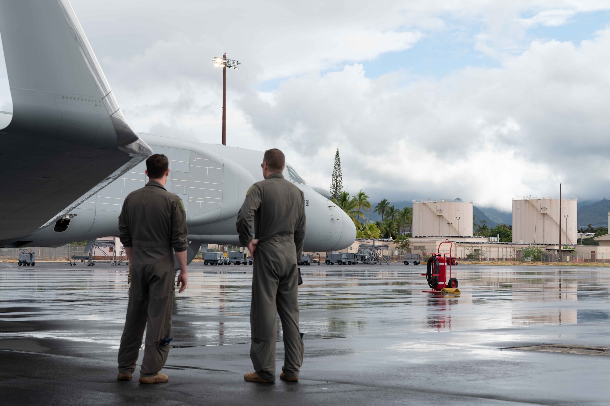 Two U.S. Air Force EA-37B Compass Call pilots examine their aircraft on Joint Base Pearl Harbor-Hickam, Hawaii, Oct. 1, 2025. The adaptable open systems architecture ensures the EA-37B will remain effective against evolving electromagnetic threats, providing long-term value for defense investment. (U.S. Air Force Photo by Senior Airman Mark Sulaica)