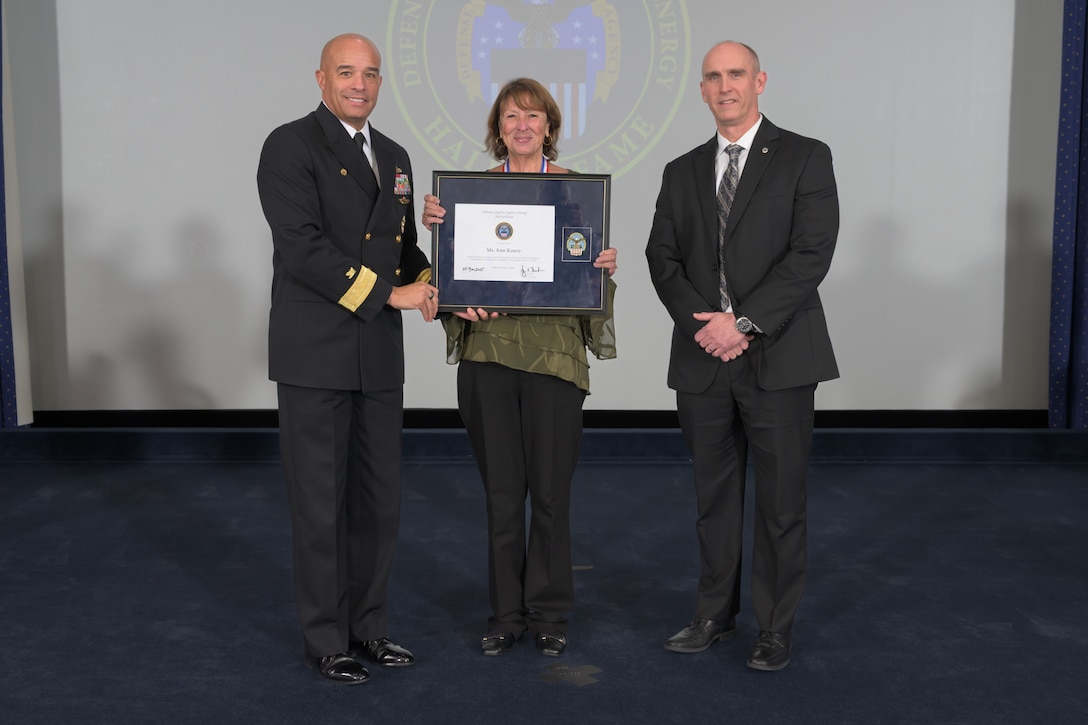 The people pose for photos while on stage at ceremony.