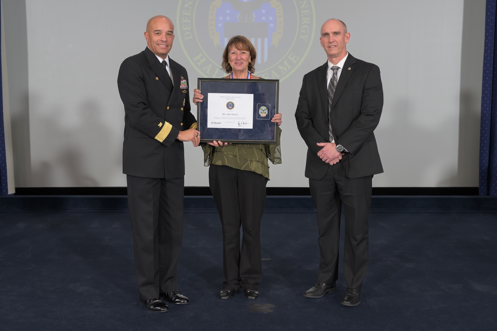 People pose for photos while on stage at ceremony.