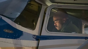 A pilot in training looks into the cockpit of a Cessna he is about to fly.