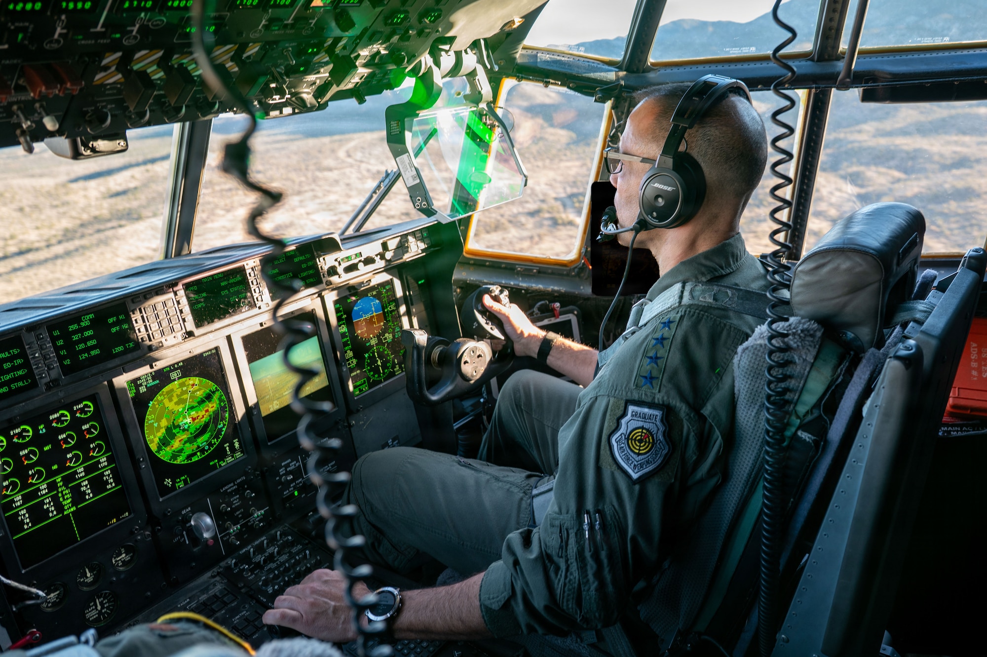 Gen. Adrian Spain sits in a cockpit, piloting an HC-130J Combat King II.