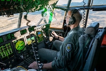 Gen. Adrian Spain sits in a cockpit, piloting an HC-130J Combat King II.