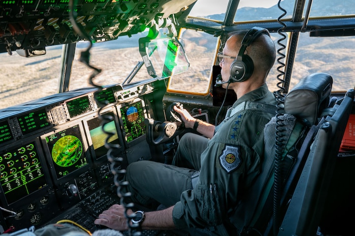 Gen. Adrian Spain sits in a cockpit, piloting an HC-130J Combat King II.