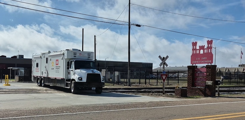 A Deployable Tactical Operations System vehicle pulls out of a parking lot.