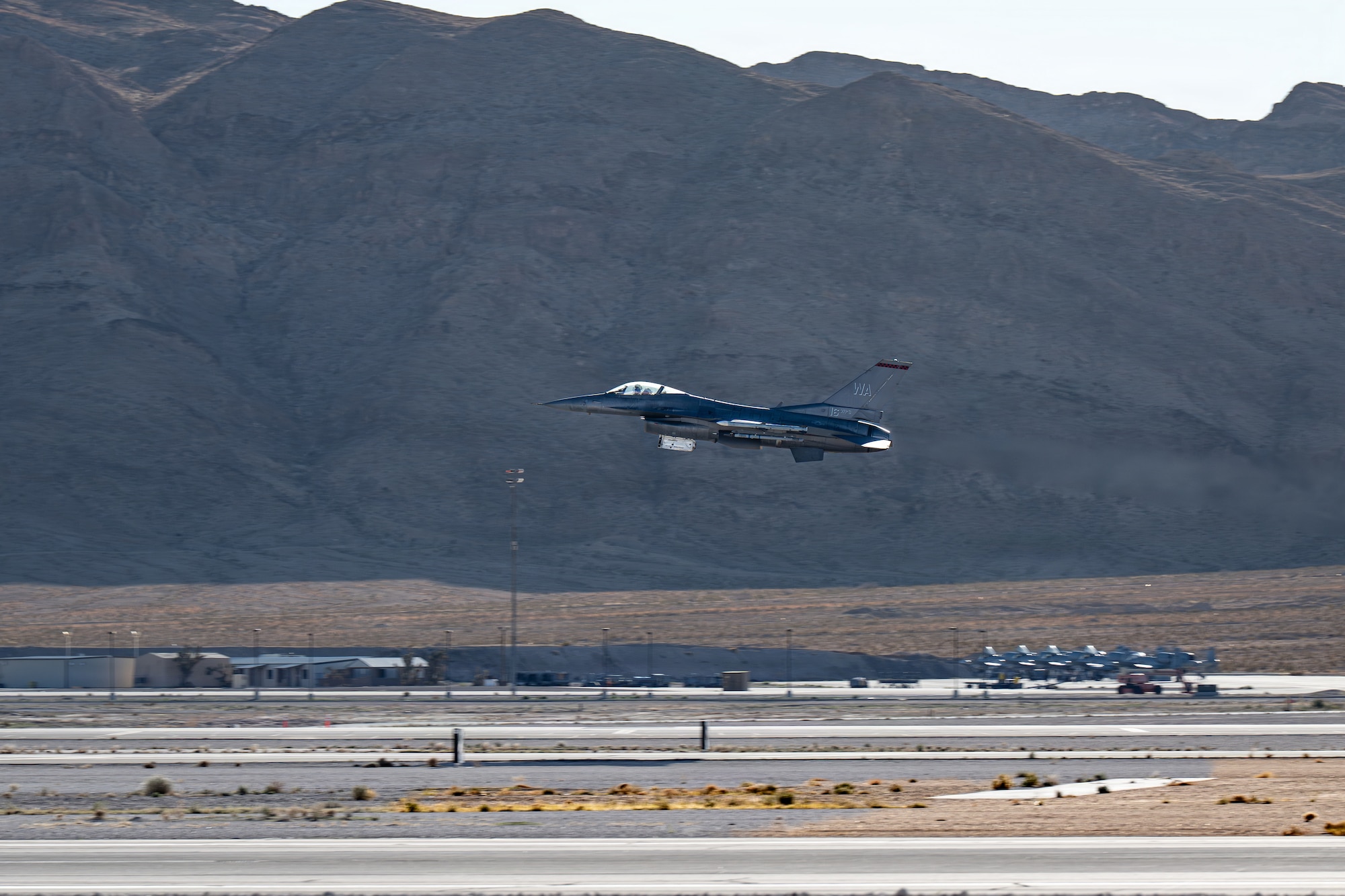 An F-16 Fighting Falcon takes off from the runway at Nellis Air Force Base.