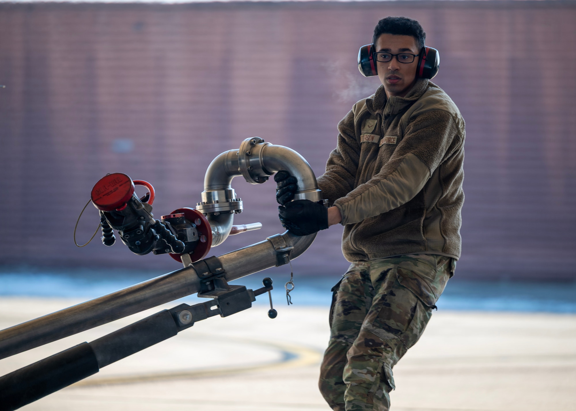 U.S. Air Force Airman 1st Class Benjamin Patterson, 51st Logistics Readiness Squadron petroleum, oils, and lubricants distribution operator, moves a pantograph during a hot-pit  refueling operation at Osan Air Base, Republic of Korea, Jan. 27, 2026. Fixed fuel hydrant systems and pantographs, allow Airmen to refuel aircraft directly from base fuel storage, reducing delays and sustaining combat airpower. (U.S. Air Force photo by Staff Sgt. Sarah Williams)