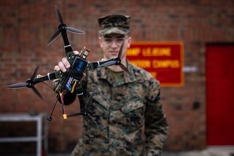 U.S. Marine Corps Sgt. Henry David Volpe, an automotive maintenance technician with 2nd Maintenance Battalion, 2nd Combat Readiness Regiment, 2nd Marine Logistics Group, poses for a photo with the HANX drone he designed at Marine Corps Base Camp Lejeune, North Carolina, Jan. 23, 2026. The HANX is the Marine Corps' first National Defense Authorizing Act-compliant, 3D-printed drone, providing a secure and adaptable aerial platform for the modern warfighter. (U.S. Marine Corps photo by Sgt. Alfonso Livrieri)