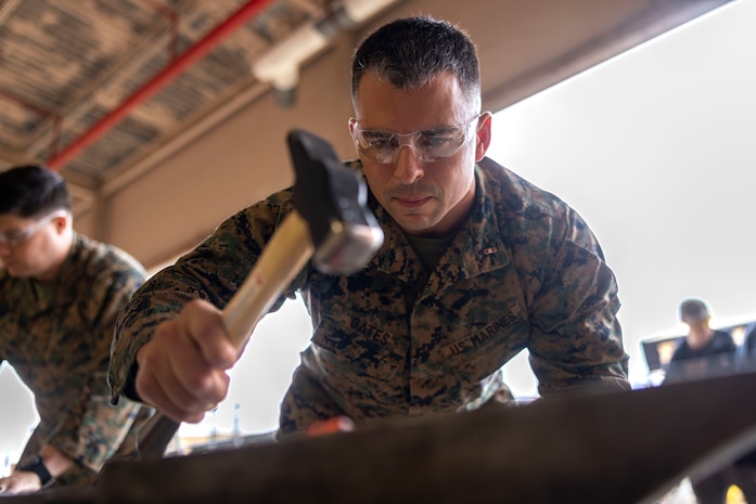 U.S. Marine Corps Chief Warrant Officer 3 Zachary Gates, a ground electronics maintenance officer with 2nd Maintenance Battalion, 2nd Combat Readiness Regiment, 2nd Marine Logistics Group, forges a knife during a blacksmithing class held by Black Horse Forge at Marine Corps Base Camp Lejeune, North Carolina, Dec. 2, 2025. This event was organized by 2nd Marine Logistics Group U.S. Navy chaplains with the goal of boosting morale throughout the holiday season while providing Marines and Sailors with a sense of accomplishment, personal well-being and brotherhood. (U.S. Marine Corps photo by Lance Cpl. Isabella Ramos)
