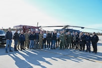 Southampton Fire Department First Assistant Chief Ricky Fowler, right, and Capt. Jason Poremba, left, present representatives of the New York Air Guard’s 106th Rescue Wing and Army Guard’s 3rd Battalion, 142nd Assault Helicopter Battalion with a framed photograph at Francis S. Gabreski Air National Guard Base in Westhampton Beach, New York, Jan. 9, 2026.