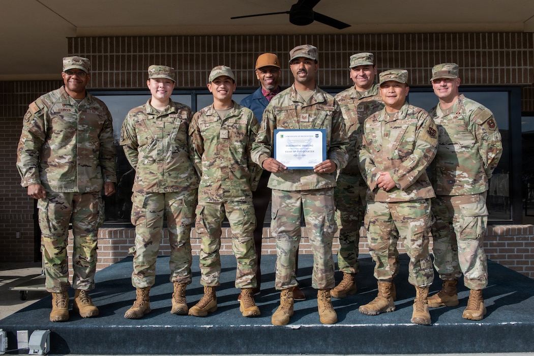 People in military uniforms pose for a group photo.