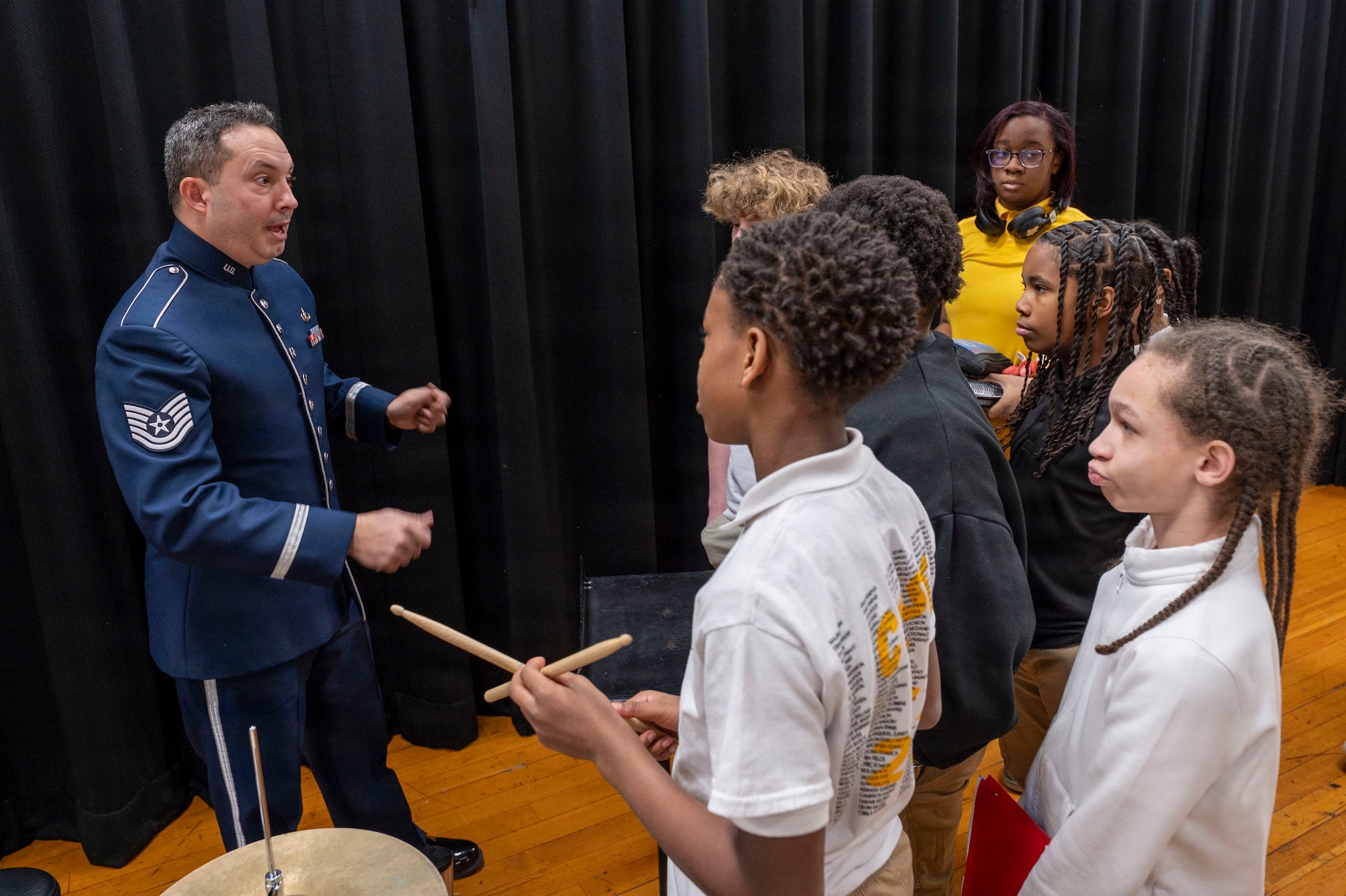 U.S. Air Force Tech. Sgt. Luis Rivera, percussionist with The U.S. Air Force Band’s Ceremonial Brass, speaks with Gwynn Park Middle School band students in Brandywine, Md., Jan. 15, 2026. Students asked the Airmen questions following the performance, including how long the musicians had played their instruments, if they had ever wanted to quit, and how much they got paid. (U.S. Air Force photo by Staff Sgt. Jordan Powell)