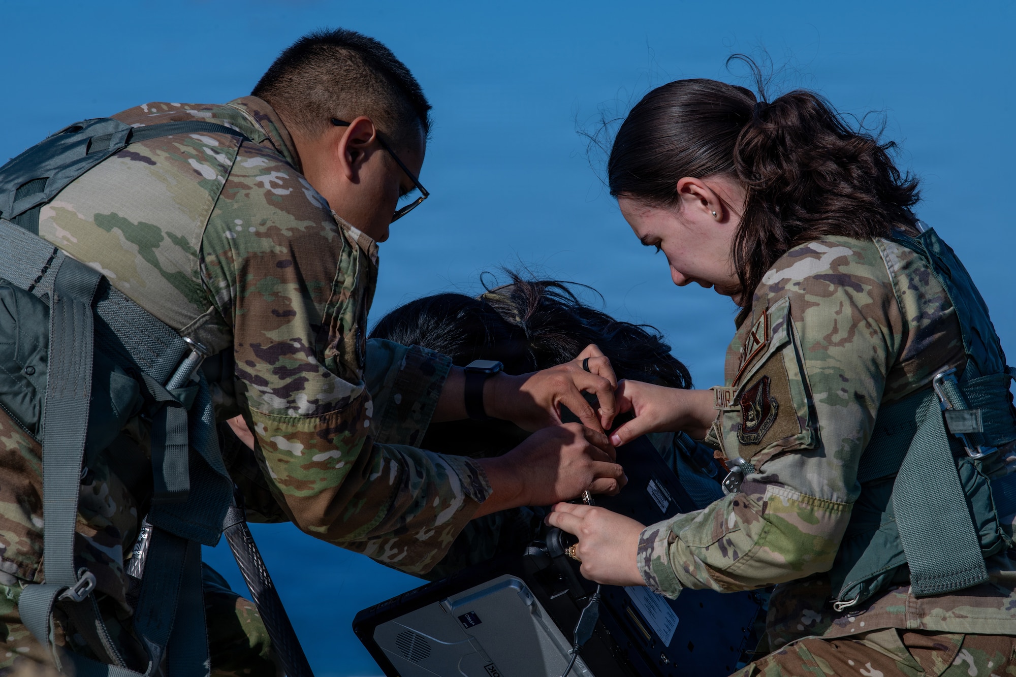 Service members set up weather sensor equipment.