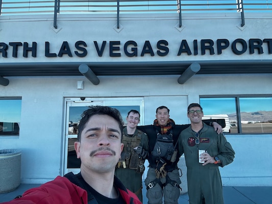 Hospital Corpsman 1st Class Brian Romero (left), a Navy Medicine Sailor and search and rescue (SAR) medical technician; Chief Hospital Corpsman Albert Tran (center), VX-31 SAR shop leading chief petty officer; Lt. George Smith (center-right), pilot; and Mr. Matthew McDermott (right), pilot, pose for a photo at North Las Vegas Airport following a successful search and rescue mission Dec. 3, after transporting an ejected F-16 pilot to a Level I trauma center. The VX-31 SAR team, operating under the call sign Rescue 463, provided rapid response and coordinated medical evacuation in support of aviator safety. (Courtesy photo)
