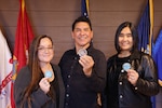 From left, Ms. Paula Curielabreu, Mr. Robert Villalobos, and Ms. Maria Lourdes Gregorio, all civilian employees at Naval Medical Forces Pacific (NMFP), pose for a photo with coins received from Dr. Michael McGinnis, executive director for the Navy’s Bureau of Medicine and Surgery and director of Navy Medicine’s Civilian Corps Jan. 26, 2026. McGinnis presented each of them with a coin in recognition of their outstanding contributions and sustained superior performance in support of the NMFP mission. (DoW photo by Regena Kowitz/Released)