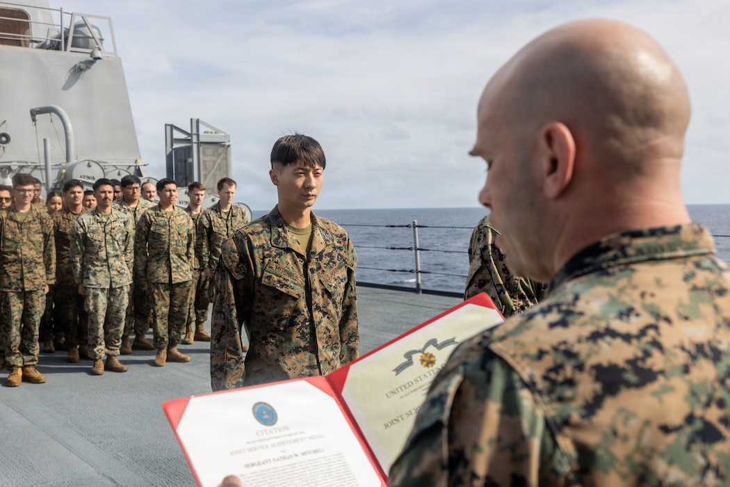 A U.S. Marine with the 22nd Marine Expeditionary Unit (Special Operations Capable), is awarded the Joint Service Achievement Medal during a ceremony aboard San Antonio-class amphibious transport dock USS Fort Lauderdale (LPD 28), while underway in the Caribbean Sea, Jan. 13, 2026. U.S. military forces are deployed to the Caribbean in support of the U.S. Southern Command mission, Department of War-directed operations, and the president’s priorities to disrupt illicit drug trafficking and protect the homeland. (U.S. Marine Corps photo)