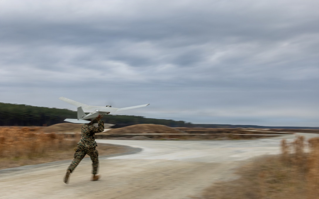 U.S. Marine Corps Cpl. Brian Kimani, a Kenya native, and a crew chief with Alpha Company, 2nd Assault Amphibian Battalion, 2nd Marine Division, launches a RQ-20B Puma unmanned aircraft system during a gunnery qualification range on Marine Corps Base Camp Lejeune, North Carolina, Jan. 23, 2026. The collective gunnery range training was held to maintain mission readiness and for Marines with 2nd AA Battalion to apply their knowledge of vehicle familiarization and weapon sustainment into simulated real-world events. (U.S. Marine Corps photo by Lance Cpl. Preston Morris).