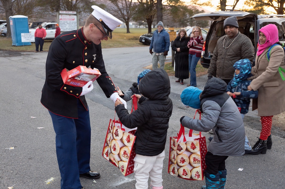 U.S. Marine Corps Pvt. Preston Dunford, command recruiting program Marine, passes out candy and stickers to children during the Stuarts Draft Christmas Parade in Stuarts Draft, Virginia on Dec. 13, 2025. The Stuarts Draft Christmas Parade is an annual community event held on Draft Avenue featuring decorated floats from local businesses, churches, and groups, and allows the Marines to connect with the community and spread holiday cheer. (U.S. Marine Corps photo by Cpl. Trion D. Jenkins)
