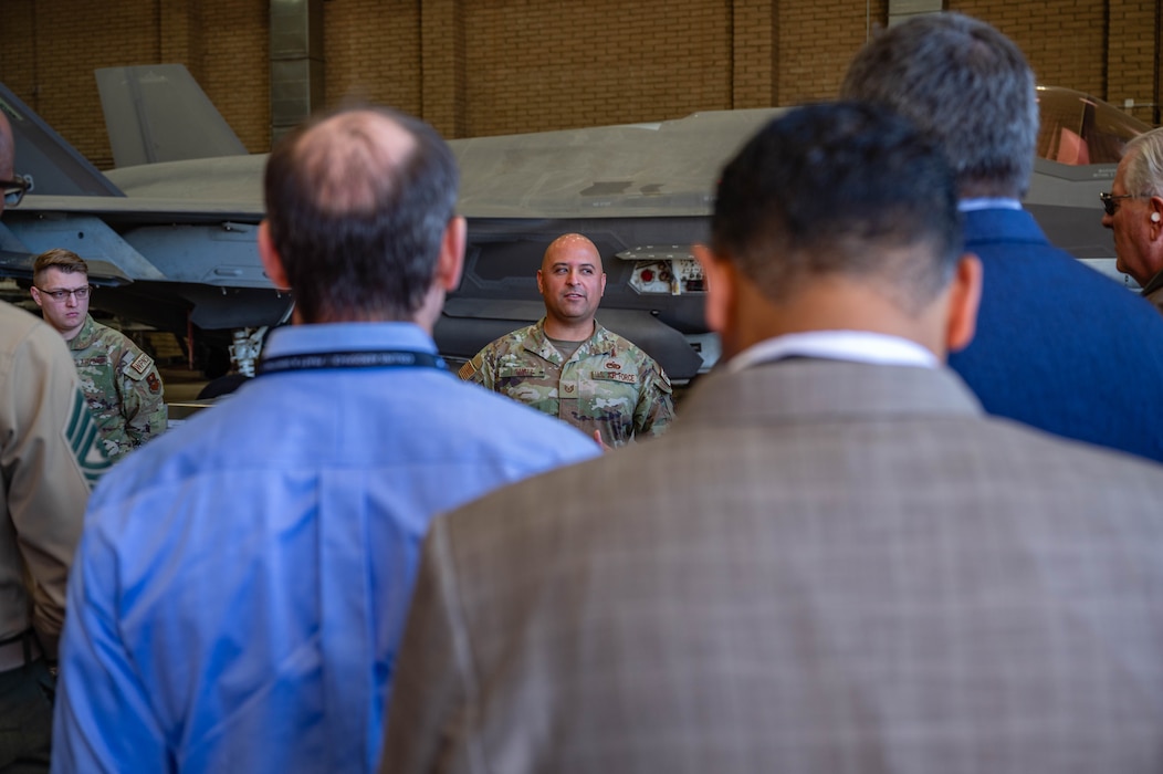 Members of the Department of War Maintenance Symposium, listen to U.S. Air Force Tech. Sgt. Diego Lomeli, 56th Component Maintenance Squadron loading standardization crew member, talk about the operations of the Aircraft Maintenance Units , Jan. 20, 2026, at Luke Air Force Base, Arizona.
