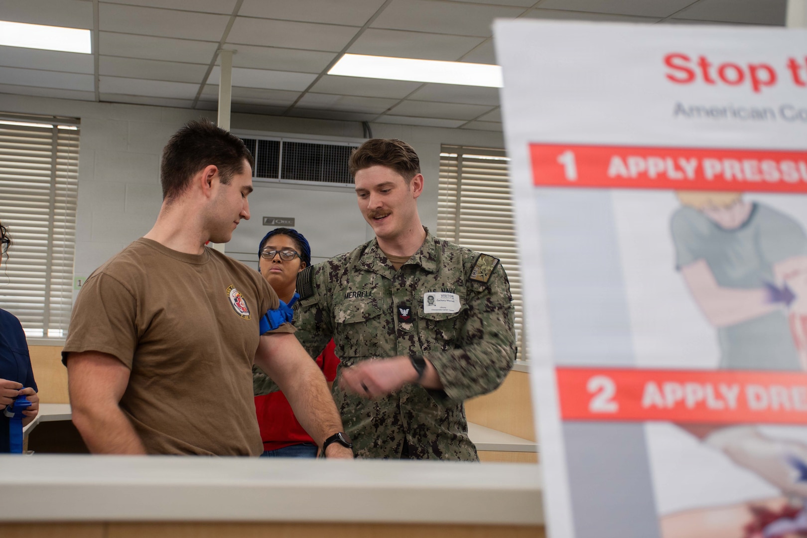 Hospital Corspman 2nd Class Malachi Gregory and Hospital Corpsman 2nd Class Zachary Merrel, both assigned to Naval Medical Center Portsmouth (NMCP), demonstrate the proper application of a tourniquet to students from local schools during a Stop The Bleed event at the Chesapeake Career Center, Jan. 23, 2025.