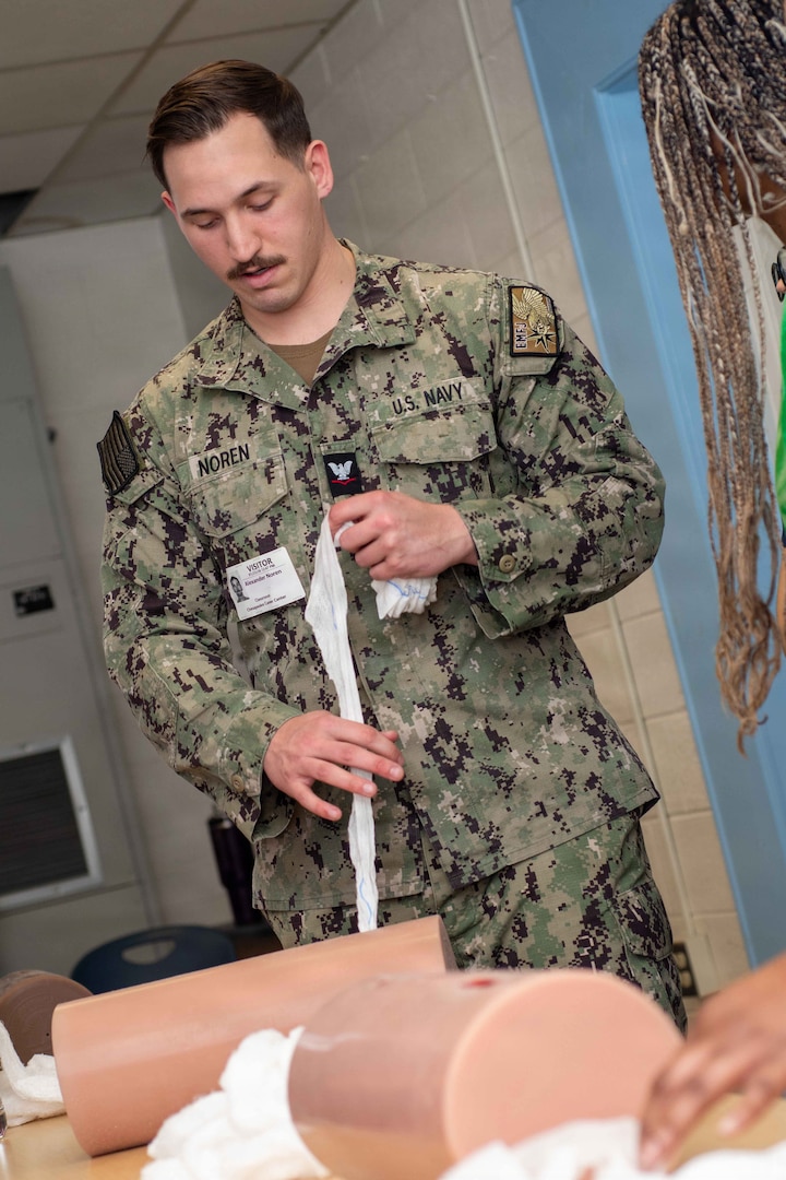 Hospital Corpsman 3rd Class Alexander Norren, assigned to Naval Medical Center Portsmouth (NMCP), uses a training dummy to teach students from local schools how to pack a wound during a Stop The Bleed event at the Chesapeake Career Center, Jan. 23, 2025.