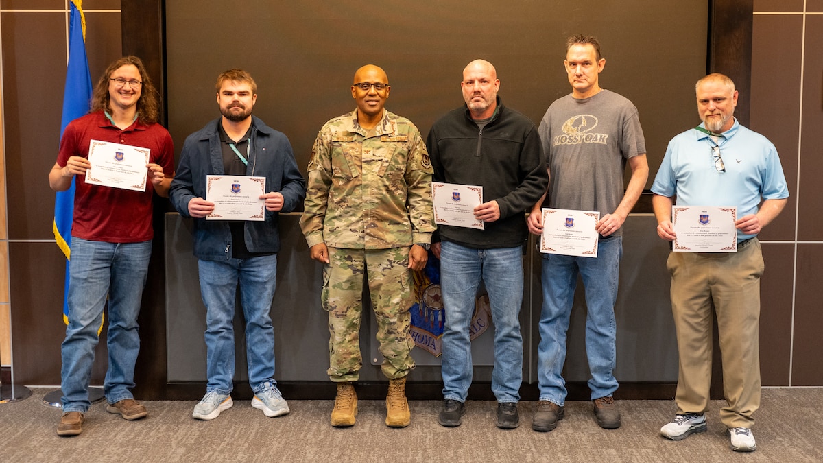 People posing with certificate