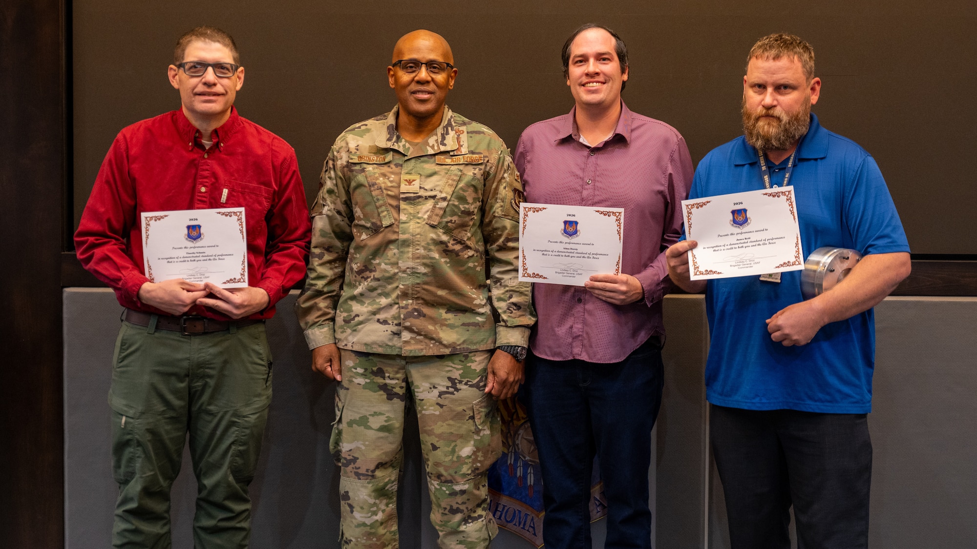 People posing with certificate