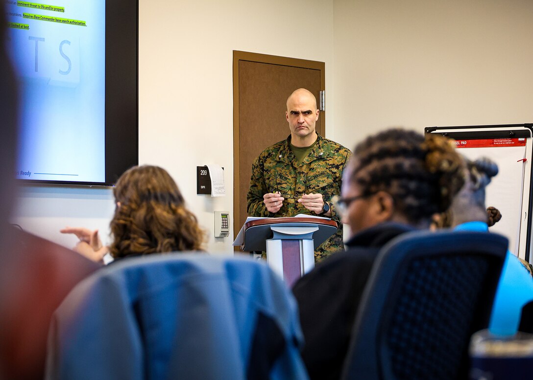 U.S. Marine Corps Lt. Col. Beau Pillot, operations director, Blount Island Command, presents to federal, state, local, military and private-sector partners during an integrated base defense planning event Jan. 28, 2026, at Marine Corps Support Facility Blount Island, Florida. The two-day event focused on strengthening regional coordination and resilience to support mission continuity in a contested environment. (Official Marine Corps photo by Cpl. Nicholas Martinez)