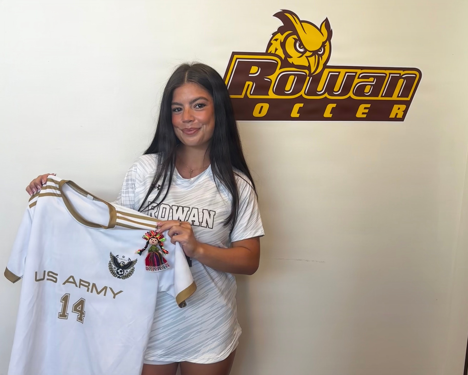 U.S. Army 1st Lt. Daniela McCurdy, a human resources officer with the 56th Stryker Brigade Combat Team, 28th Infantry Division, Pennsylvania National Guard, poses for a photo in her Rowan uniform with her jersey from her time playing soccer with Area Support Group - Kuwait during a media day event in Glassboro, New Jersey, Aug. 27, 2025. (Courtesy Photo)