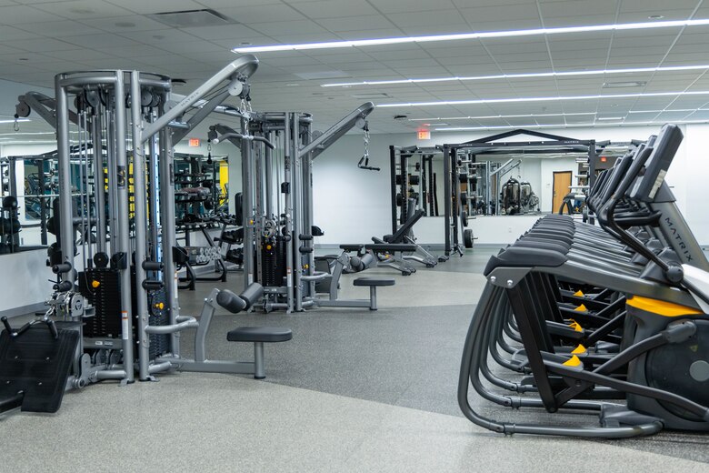 Gym equipment sits in a room with grey walls and grey floor.