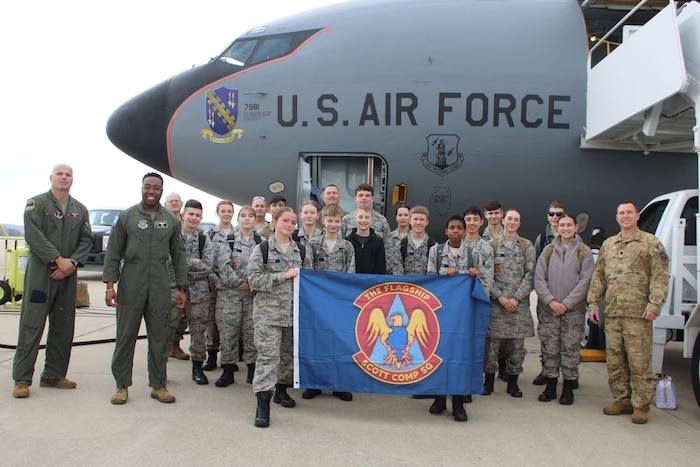 A group photo in front of a plane