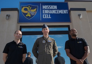 U.S. Air Force Senior Airman Ian Conners, Mission Enhancement Cell chief of technology (left), Capt. Andy Hewins, MEC chief of innovation (center) and Tech. Sgt. Kevin Mack, MEC chief of operations (right), pose outside of the MEC at Joint Base McGuire-Dix-Lakehurst, N.J., Nov. 5, 2025. The MEC equips different units and squadrons across the joint base with the tools they need to maximize efforts and solve common problems that may hinder mission efficiency. (U.S. Air Force photo by Airman 1st Class Luisa E. Dugan)