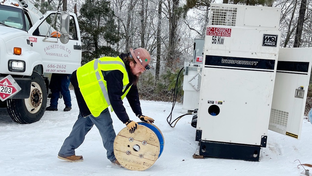 A power team member from the U.S. Army Corps of Engineers Tulsa District moves a roll of electrical cable to install a power generator at a communications tower in Bethel Springs, Tennessee, Jan. 29, 2026, to ensure first responders can communicate and coordinate recovery efforts. The USACE Nashville District’s emergency managers are supporting this effort as part of a FEMA mission assignment with Task Force Temporary Emergency Power. (USACE Photo by Matt Phelan)